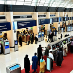 **A bustling, modern airport terminal in Pakistan.  Long lines of people are at check-in counters.  Focus on diverse Pakistani people in traditional and modern clothing, architectural details of the terminal reflecting local design, with a hint of Urdu signage.**